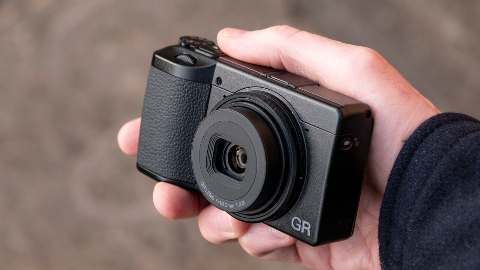 Ricoh GR IV compact camera in user's hand